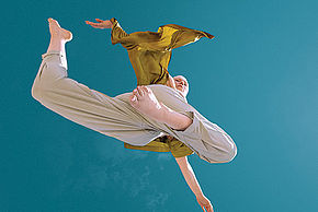 Photo d'une danseuse dans les airs sur fond bleu turquoise - Agrandir l'image