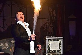Spectacle "Qui veut la peau du magicien ?" représentant un magicien effrayé les flammes qu'il produit avec sa main à Dammarie-lès-Lys