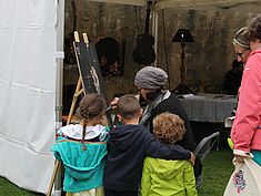 enfants qui regardent une femme peindre - Agrandir l'image (fenêtre modale)